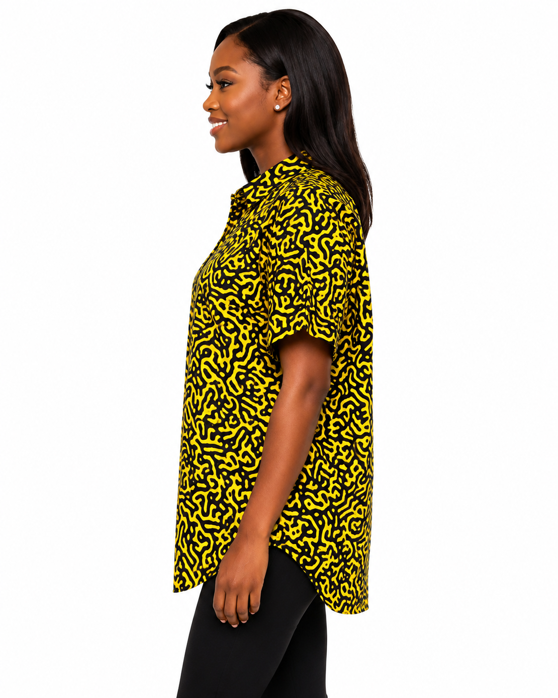 A woman shown in side profile wearing a short-sleeve button-up shirt with a bold black and yellow abstract pattern, paired with black pants, against a plain white background.